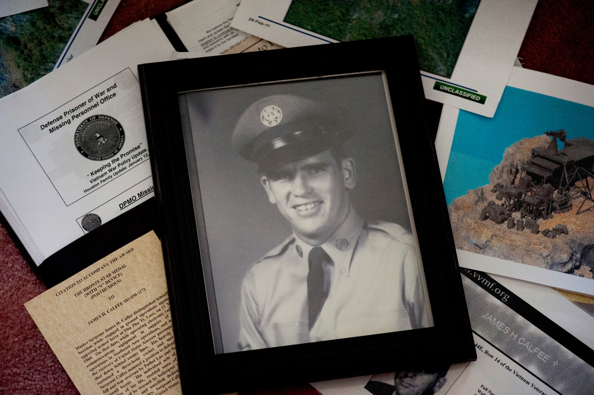 A framed photograph of the late Master Sgt. James Calfee sits among documents compiled by relatives in Houston, Texas, Aug. 22, 2012. Calfee, who was killed in action in Laos in 1968, was recently awarded the Silver Star Medal. (U.S. Air Force photo/Val Gempis)