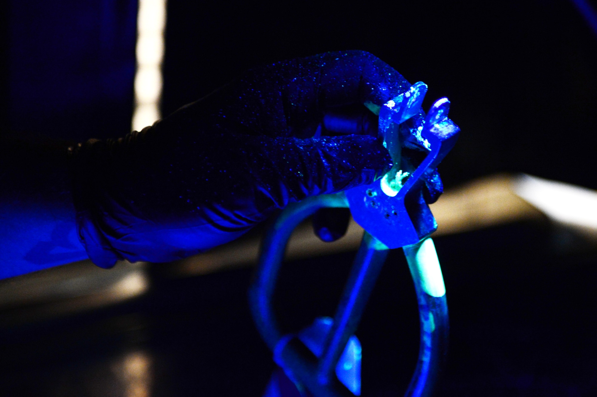 U.S. Air Force Tech. Sgt. Steven Vitale, 27th Special Operations Maintenance Squadron nondestructive inspection laboratory NCO in charge, checks for cracks in a piece of equipment using a black light inspection booth in the NDI laboratory at Cannon Air Force Base, N.M., Sept. 6, 2012. The 27 SOMXS NDI laboratory specialists have a mission to provide optimum support to the structural maintenance program through various inspections and analysis without causing damage. (U.S. Air Force photo/Airman 1st Class Eboni Reece)