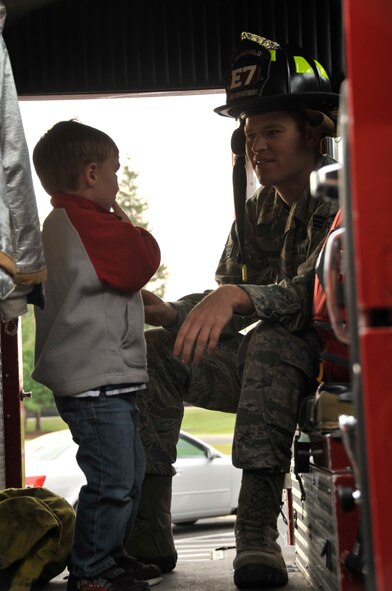 Senior Airman Russell Gredig, 92nd Civil Engineer Squadron firefighter, speaks with a child from the Child Development Center about what you see inside of a fire truck during a visit wrapping up the end of fire prevention week at Fairchild Air Force Base, Wash. Oct. 12, 2012. The children were also taught how to "stop, drop and roll" and that you should always have two ways out of your home in case of an emergency. (U.S. Air Force Photo by Airman 1st Class Mary O'Dell)
