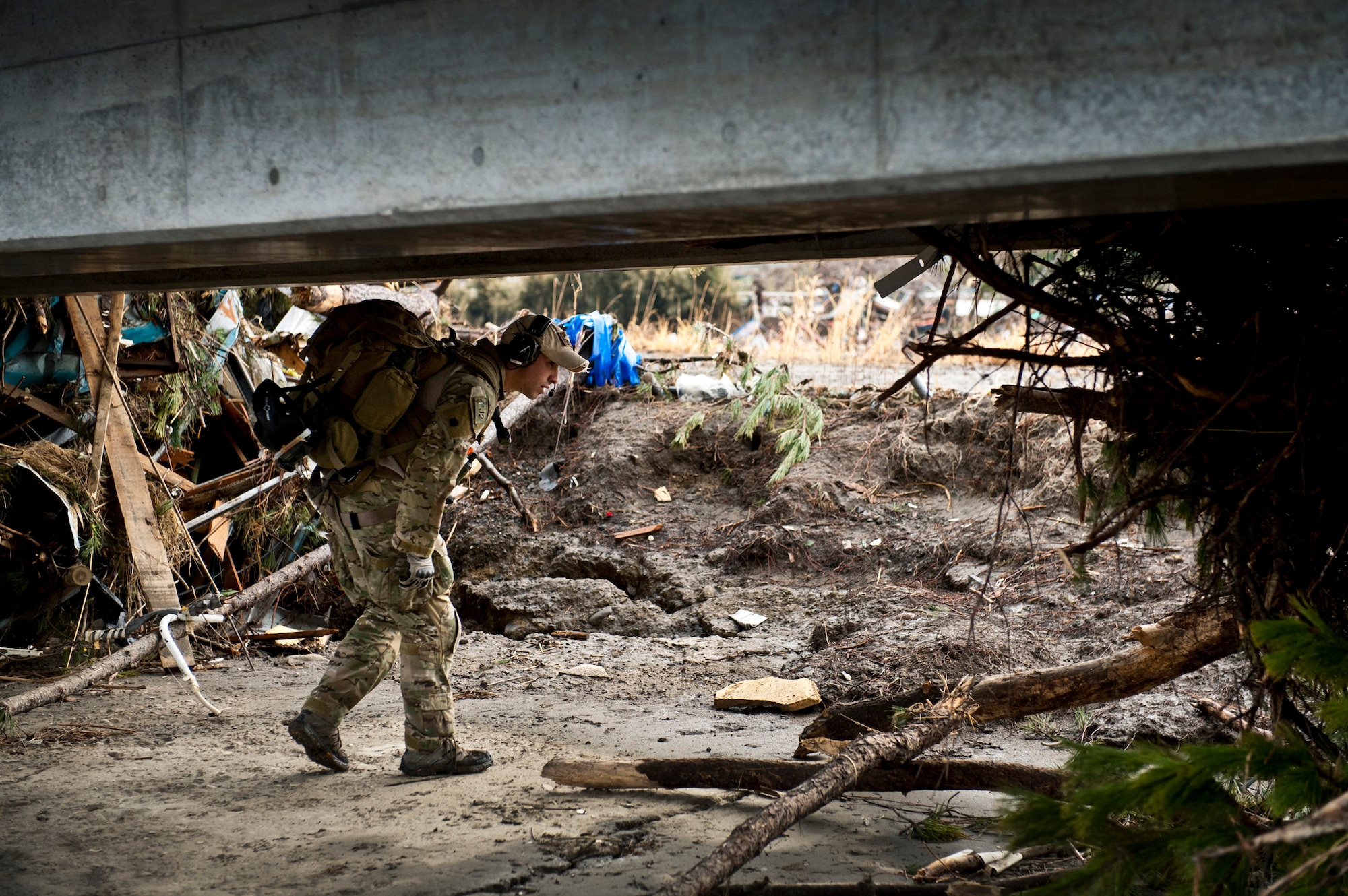 Senior Airman Steven Nizbet, 320th Special Tactics Squadron pararescueman, looks for trapped survivors March 16, 2011, at Sendai Airport, Japan during Operation Tomodachi. After an 8.9 magnitude earthquake struck northeastern Japan on March 11, it triggered a tsunami. The disasters killed an estimated 16,000 people and destroyed coastal villages, towns and cities in the Tohoku region. Within hours of the devastation, combat controllers opened the airport to ensure personnel and cargo could enter the country. At the peak of the operation, the Defense Department had 24,000 personnel, 190 aircraft, and 24 Navy ships supporting humanitarian assistance and disaster relief efforts. (U.S. Air Force photo by Staff Sgt. Samuel Morse)