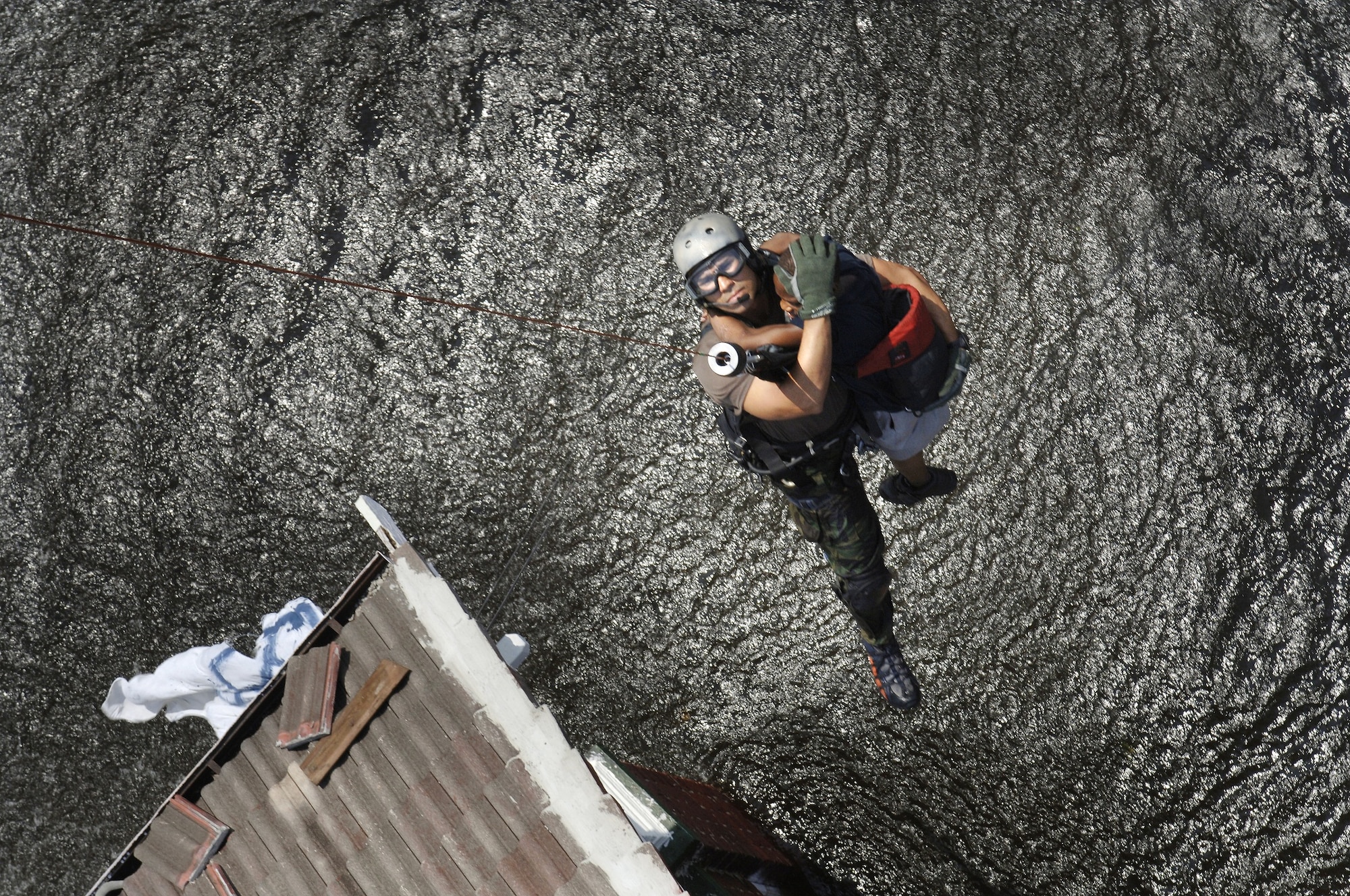 Tech. Sgt. Lem Torres, 38th Rescue Squadron pararecueman, and a young boy are lifted to safety from the roof of the child’s flooded home after Hurricane Katrina in August 2005. (U.S. Air Force photo by Staff Sgt. Manuel J. Martinez)