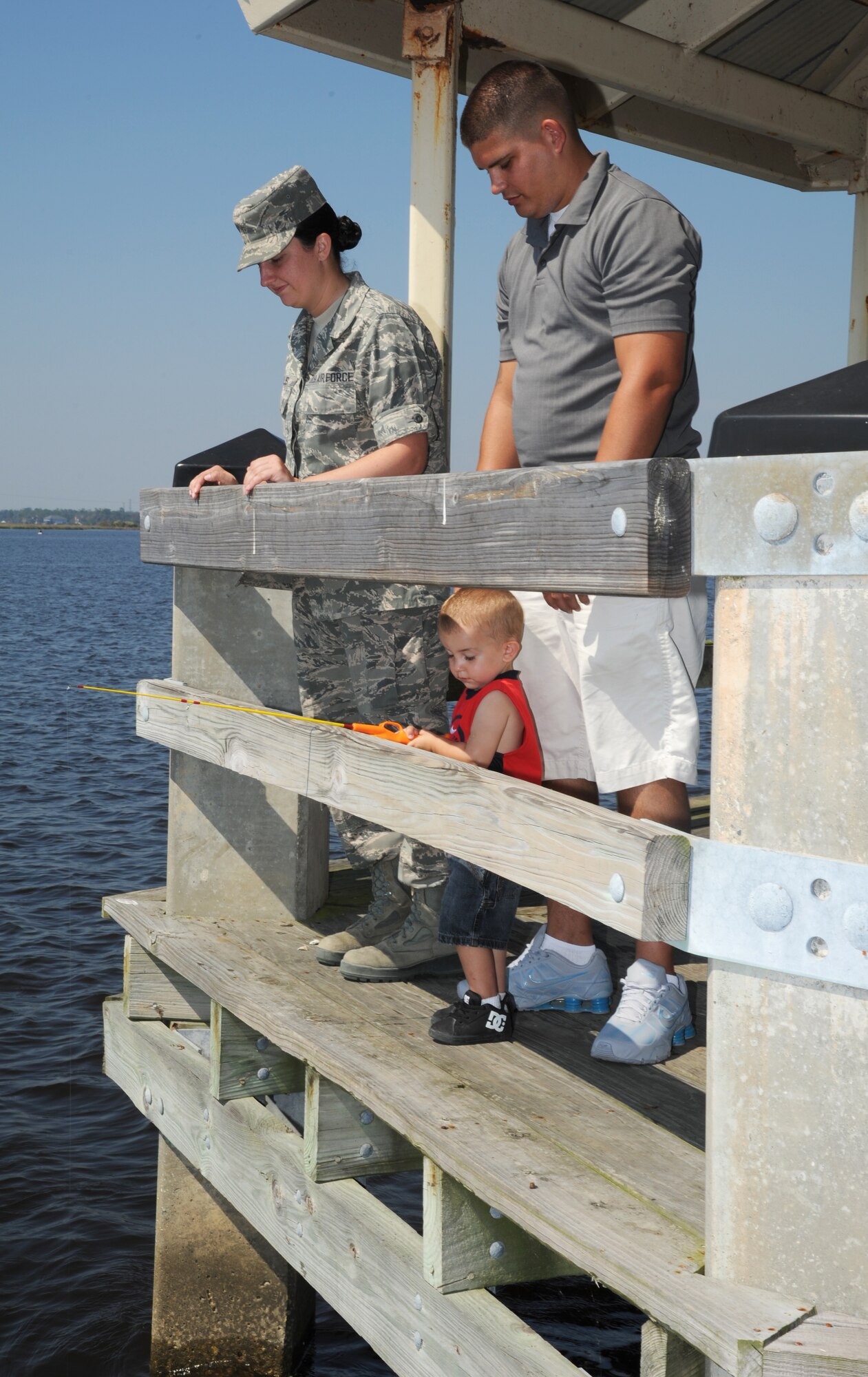 Airman Basic Nicole Willis, 335th Training Squadron, and her husband, Michael Aldridge, Sr., watch their son Michael Aldridge, Jr., 2, fish during the Kids Fall Fishing Rodeo Oct. 13, 2012, at the Keesler Marina, Keesler Air Force Base, Miss.  (U.S. Air Force photo by Kemberly Groue)