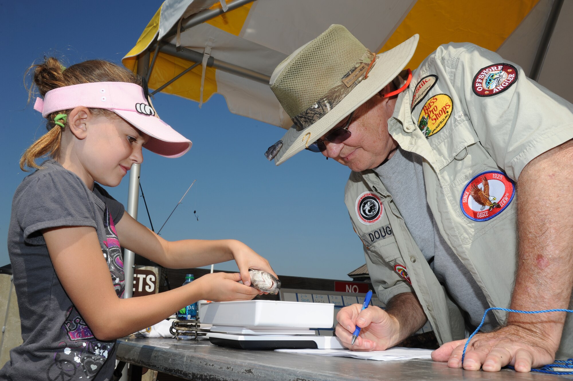 Eight-year-old Savanna Shepherd, daughter of Tammy and Master Sgt. Jim Shepherd, 403rd Wing and a civilian in the 403rd Maintenance Squadron, has her black drum weighed by Doug Stiles, 81st Force Support Squadron, at the Kids Fall Fishing Rodeo Oct. 13, 2012, at the Keesler Marina, Keesler Air Force Base, Miss.  Savanna’s fish weighed seven ounces.  (U.S. Air Force photo by Kemberly Groue)