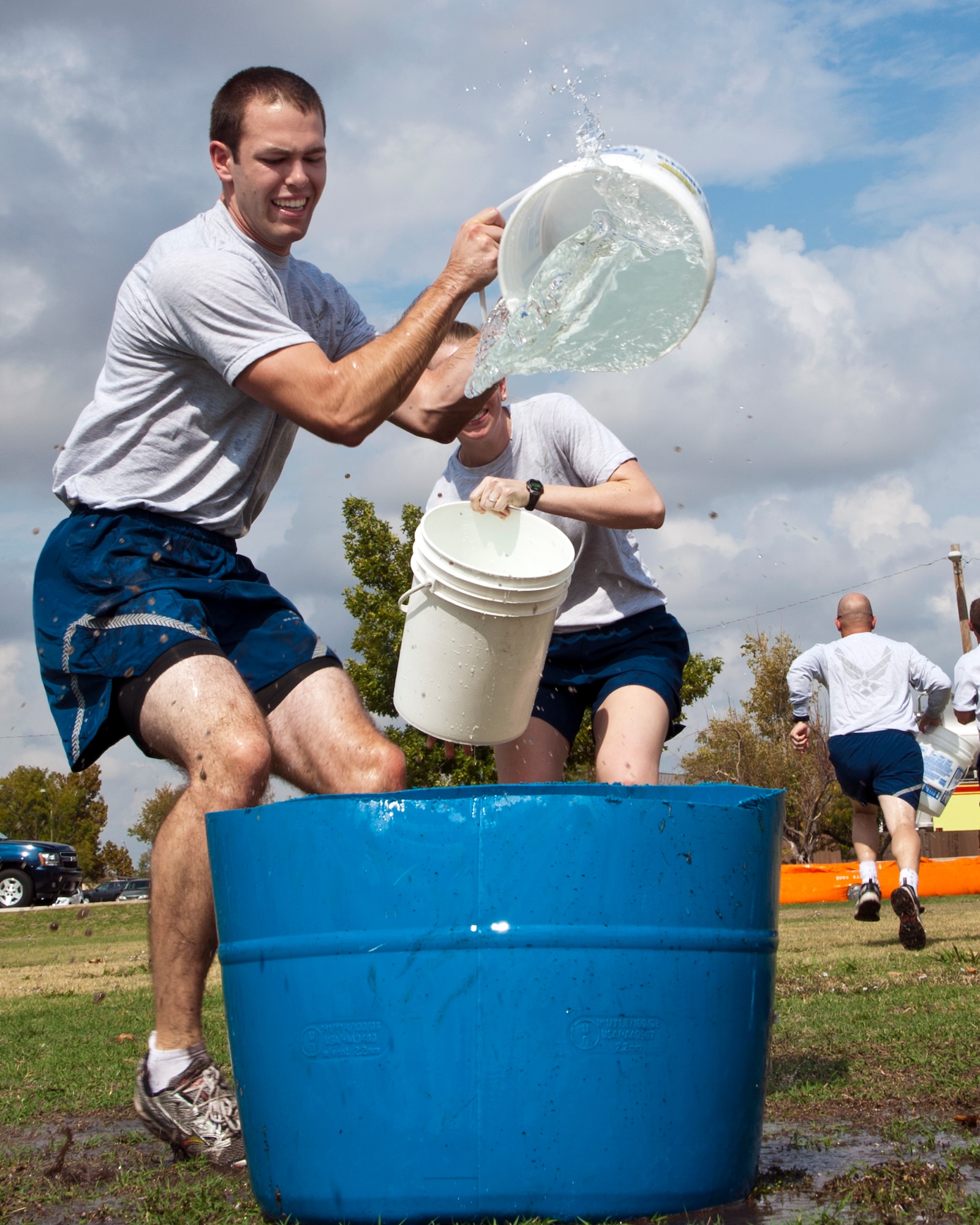 ALTUS AIR FORCE BASE, Okla. -- 2nd Lt. Tim Lord, 97th Civil Engineer Squadron programmer, participates in the Bucket Brigade event during the Fire Prevention Week Muster at Wings of Freedom Park, Oct. 12, 2012. The Muster is held annually to allow members of Altus AFB to get a glimpse of some of the challenges firefighters experience during emergency situations. (U.S. Air Force photo by Senior Airman Kenneth W. Norman / Released)