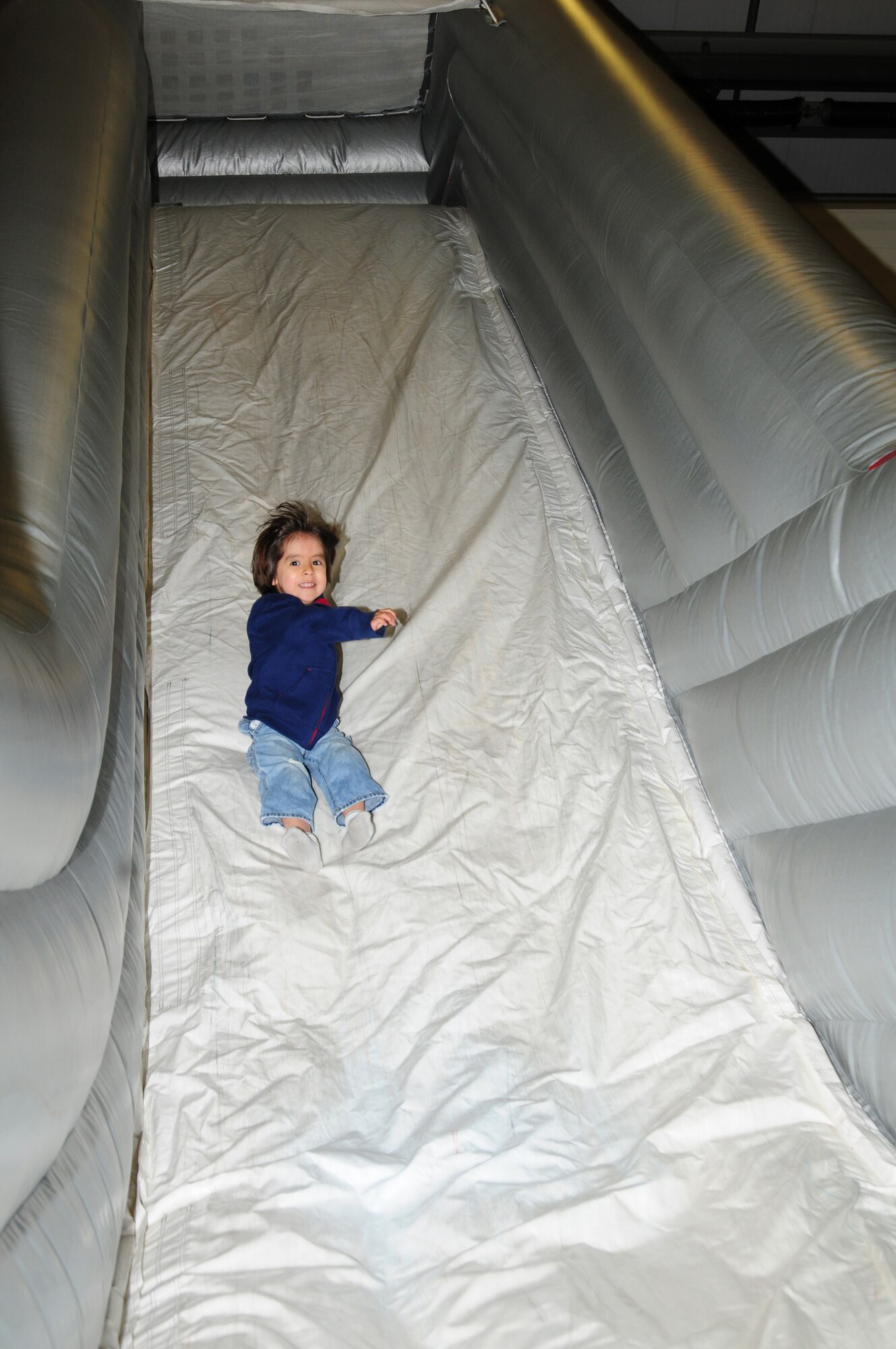 Christopher Aragon, 4, son of Tech. Sgt. Gabriel Aragon, 488th Intelligence Squadron, slides down an inflatable firetruck slide at the 100th Civil Engineer Squadron Fire Department open house Oct. 12, 2012, at RAF Mildenhall, England. The event was one of many during Fire Prevention Week. (U.S. Air Force photo by Karen Abeyasekere/Released)
 
