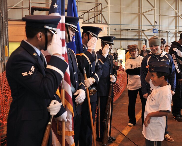 Marley Simpson, 7, salutes members of the RAF Mildenhall base honorguard during the Joan Mann Special Sports Day Oct. 13, 2012, at RAF Mildenhall, England. Simpson was one of more than 200 special athletes from the local area invited to the event. (U.S. Air Force photo by Senior Airman Jerilyn Quintanilla/Released) 