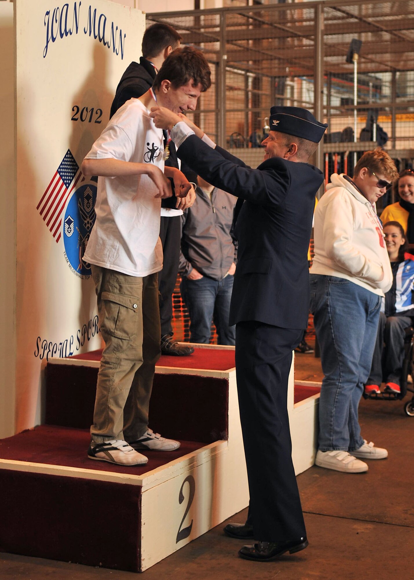 Col. Kyle Robinson, 48th Fighter Wing commander, presents a second place medal to a special athlete during the Joan Mann Special Sports Day award ceremony Oct. 13 2012, at RAF Mildenhall, England. Medals were presented to the top three scoring males and females of each event. Participation medals were given to every athlete in attendance. (U.S. Air Force photo by Senior Airman Jerilyn Quintanilla/Released) 