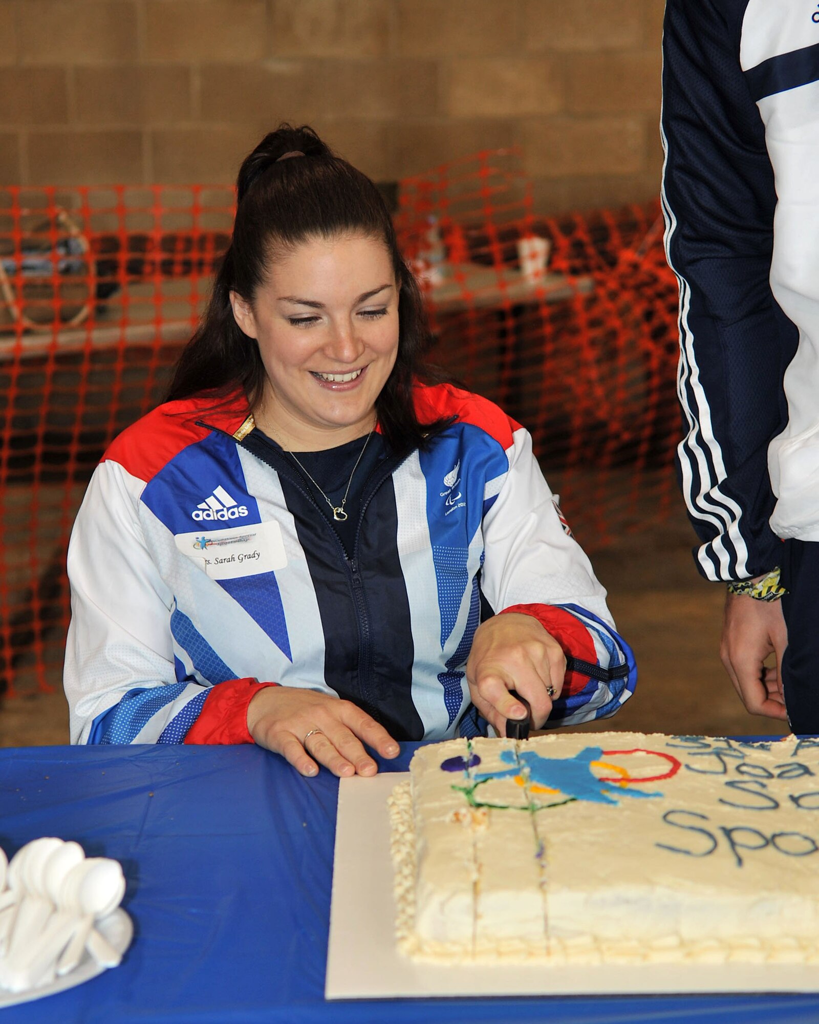 Paralympian Sarah Grady cuts the cake during Joan Mann Special Sports Day Oct. 13, 2012, at RAF Mildenhall, England. Grady and fellow Paralympian Jonathan Adams were among the special guests invited to the base to celebrate the 31st anniversary of the event. (U.S. Air Force photo by Senior Airman Jerilyn Quintanilla/Released)