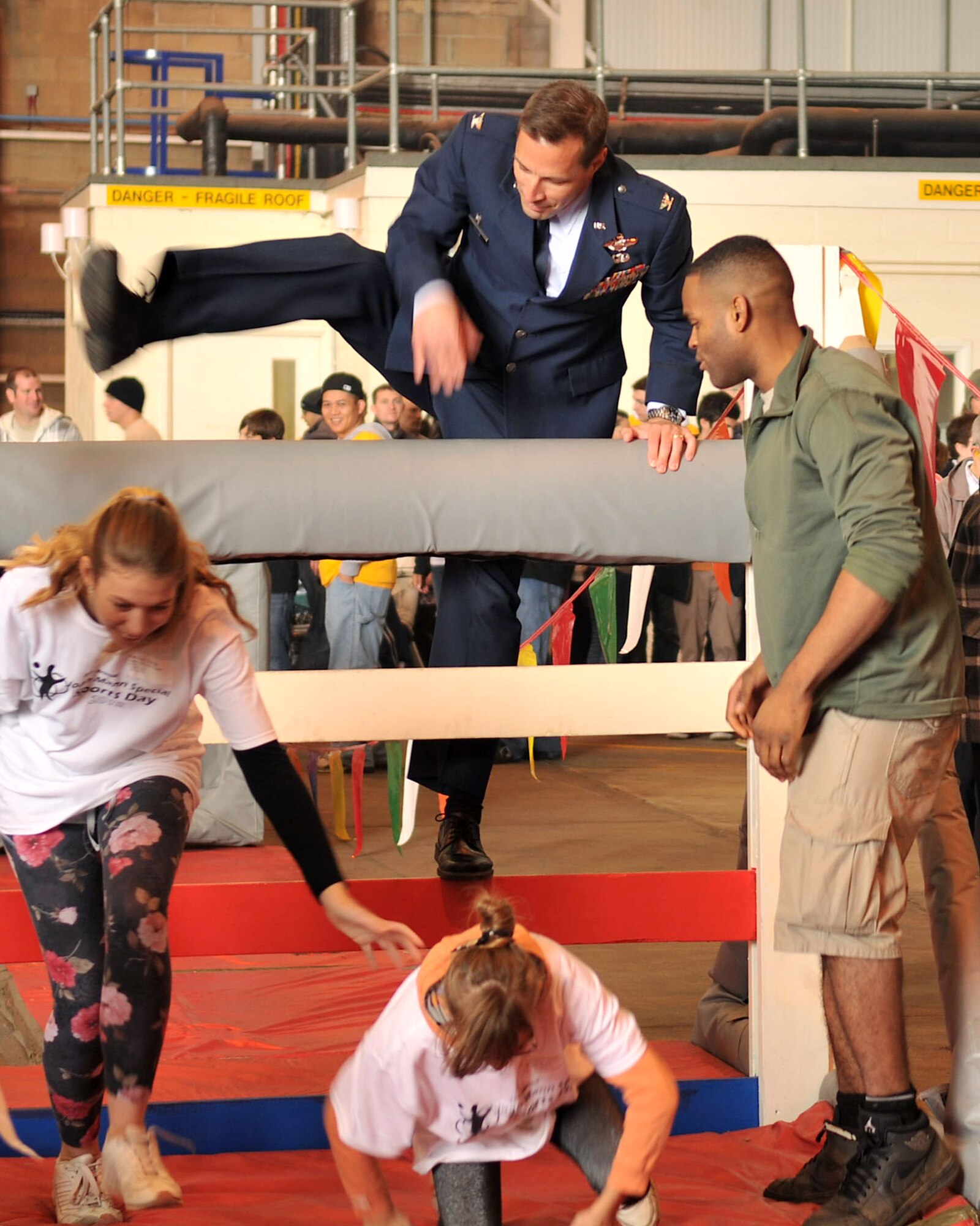 Col. Christopher Kulas, 100th Air Refueling Wing commander, makes his way over the hurdle of an obstacle course during Joan Mann Special Sports Day Oct. 13, 2012, at RAF Mildenhall, England. In addition to the obstacle course, activities such as a ring toss, tennis ball bounce, basketball and bowling were set up for the athletes. (U.S. Air Force photo by Senior Airman Jerilyn Quintanilla/Released)