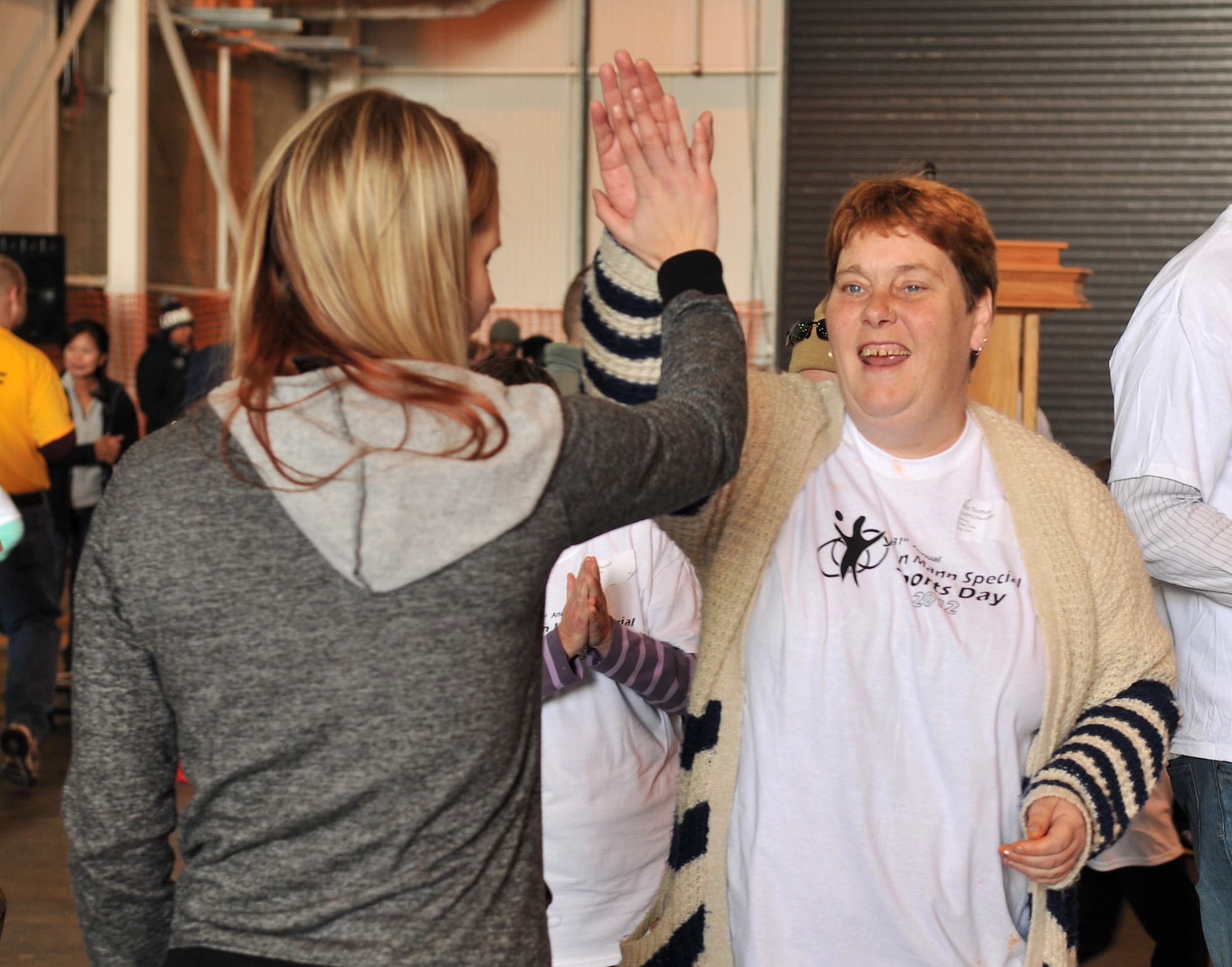 Danae Falcon, left, spouse of Senior Airman Jacob Falcon, 100th Maintenance Squadron, gives a high five to Josie Norton following a win in the ring toss game Oct. 13, 2012, at RAF Mildenhall, England. In addition to the ring toss, games such as bowling, an obstacle course, basketball and Frisbee toss were set up for the 31st anniversary Joan Mann Special Sports Day. (U.S. Air Force photo by Senior Airman Jerilyn Quintanilla/Released)