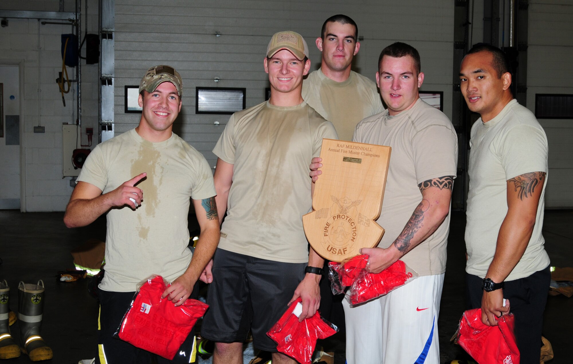 Airmen from the 100th Security Forces Squadron ‘Raptor 56’ team show off their plaque for first place after the fire muster Oct. 11, 2012, at the 100th Civil Engineer Squadron Fire Department, RAF Mildenhall, England. They completed the event in 9 minutes 37 seconds, beating five other teams. (U.S. Air Force photo by Karen Abeyasekere/Released)