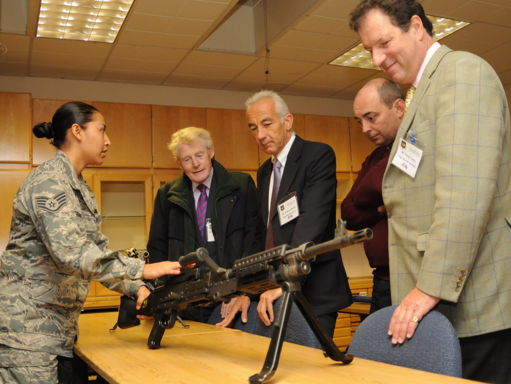 Staff Sgt. Elizabeth Briones, 48th Security Forces Squadron Defense University instructor, shows an M240B machine gun to members of a community relations tour Oct. 12, 2012, at RAF Feltwell, England. The tour group was hosted by U.S. Air Forces in Europe - United Kingdom and consisted of the high sheriffs of several counties, their spouses and several other distinguished guests. The tour group visited RAF Mildenhall, RAF Lakenheath and RAF Feltwell. (U.S. Air Force photo by Tech. Sgt. Neal X. Joiner/Released)