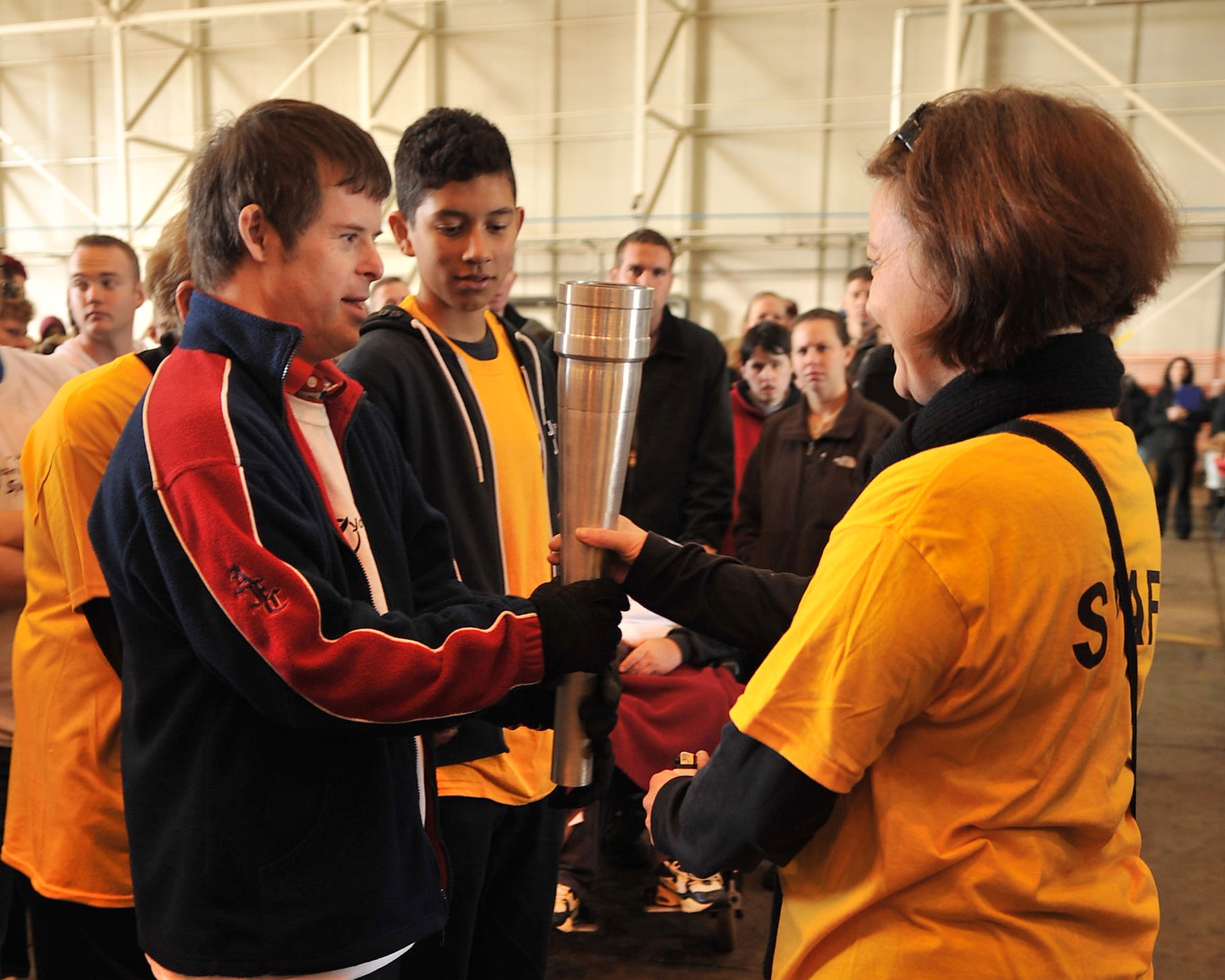 Neil Draper receives the torch prior to the Parade of Champions during Joan Mann Special Sports Day Oct. 13, 2012, at RAF Mildenhall, England. The parade signified the start of the day’s events. (U.S. Air Force photo by Senior Airman Jerilyn Quintanilla/Released)