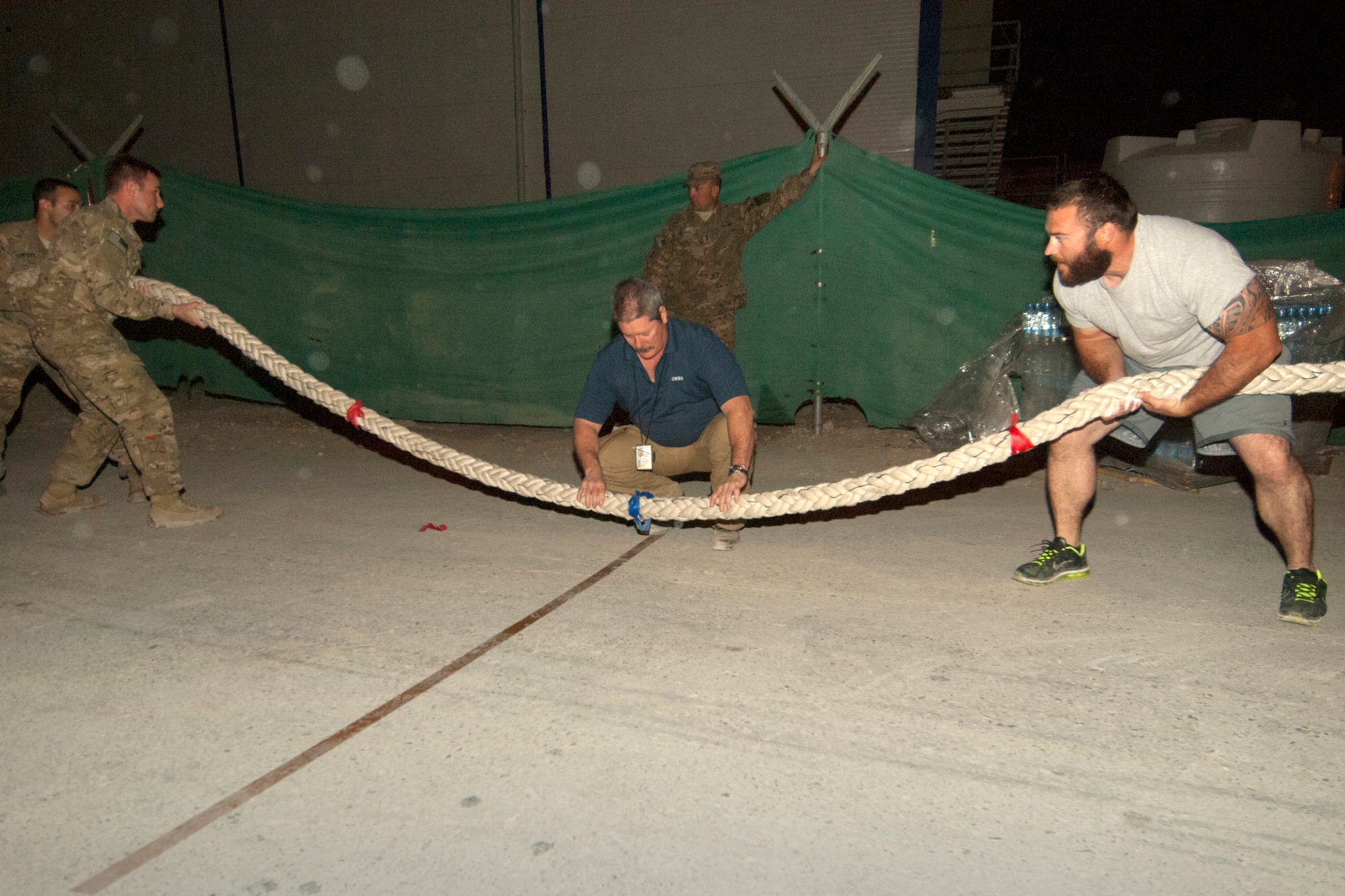 U.S. Airmen, Soldiers and civilians participate in a tug-of-war at Bagram Airfield, Afghanistan, Oct. 13, 2012. The tug-of-war was a “two out of three” contest with two five-man teams competing. “Team America” came out on top by winning the first two matchups. The team included Airmen from the 455th Expeditionary Security Forces Squadron, Air Force Office of Special Investigations, and contractors. (U.S. Air Force photo/SSgt Jeff Nevison)