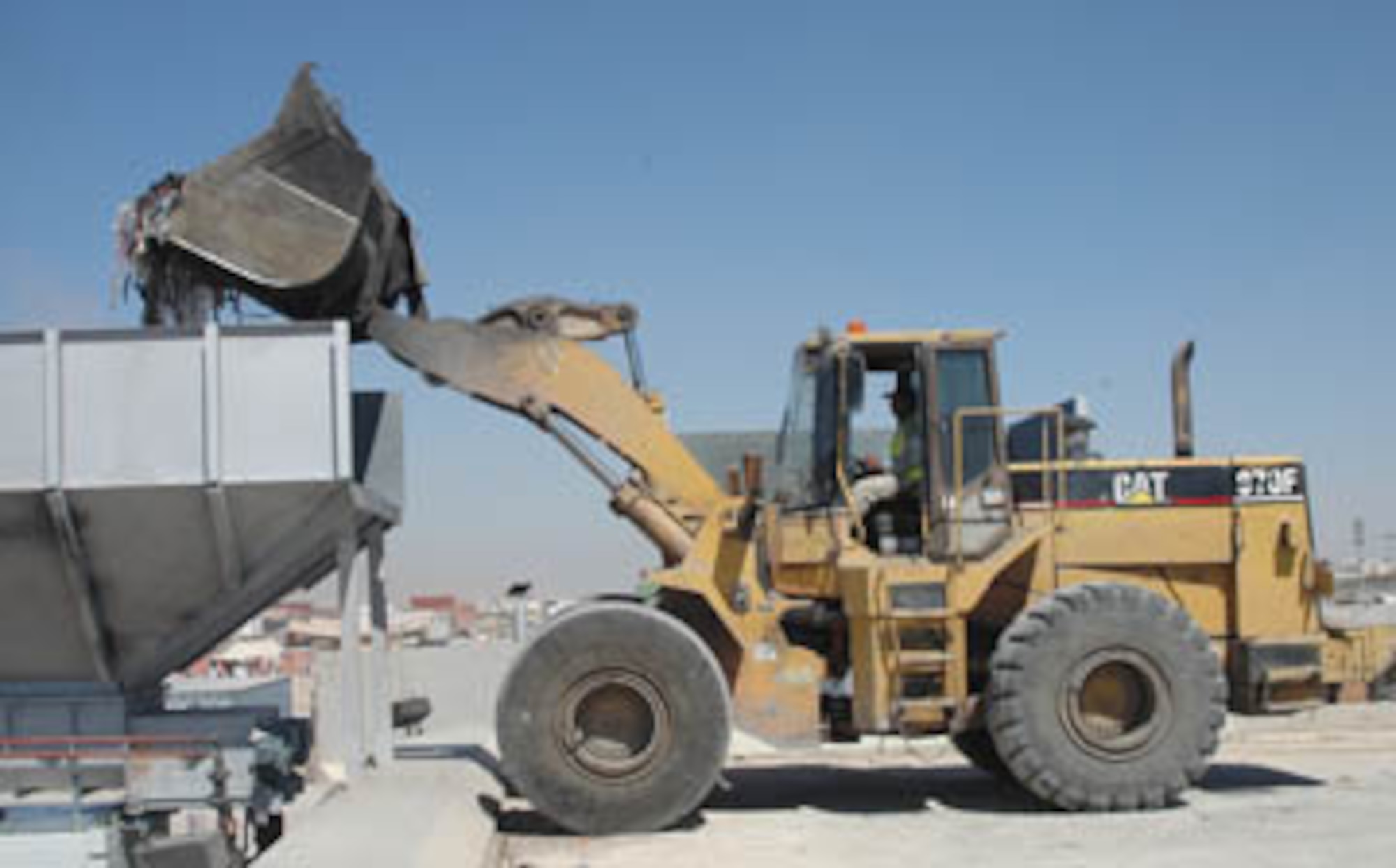 A load of trash is moved to an incinerator at the new Deep South Waste Yard on Kandahar Airfield on Oct. 6. About 100 tons of rubbish can be processed at the waste yard each day. INSET: Brig. Gen. Scott Dennis, the commander of Kandahar Airfield, marked the opening of the new waste yard by turning on the yard’s incinerators on Oct. 5. (U.S. Army photo/Sgt. 1st Class Erick Studenicka, 117th Mobile Public Affairs Detachment)