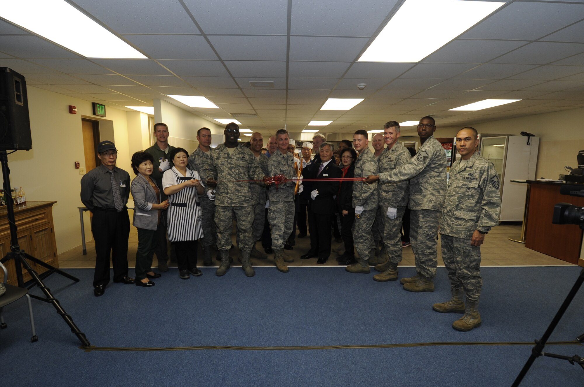 Col. John Pearse and guests at the official opening of the D-Pad Dining Facility cut the ribbon Oct. 10, 2012, on Kunsan Air Base, Republic of Korea. Airmen and servicemembers who work on the flightline can now enjoy convenient meals closer to their job sites without having to walk to the central dining facility on base. The Air Force will save more than $200,000 in basic allowance for subsistence and dissuade Airmen from turning to fast food for their meal options, keeping them fit to fight. (U.S. Air Force photo/Senior Airman Jessica Hines) 