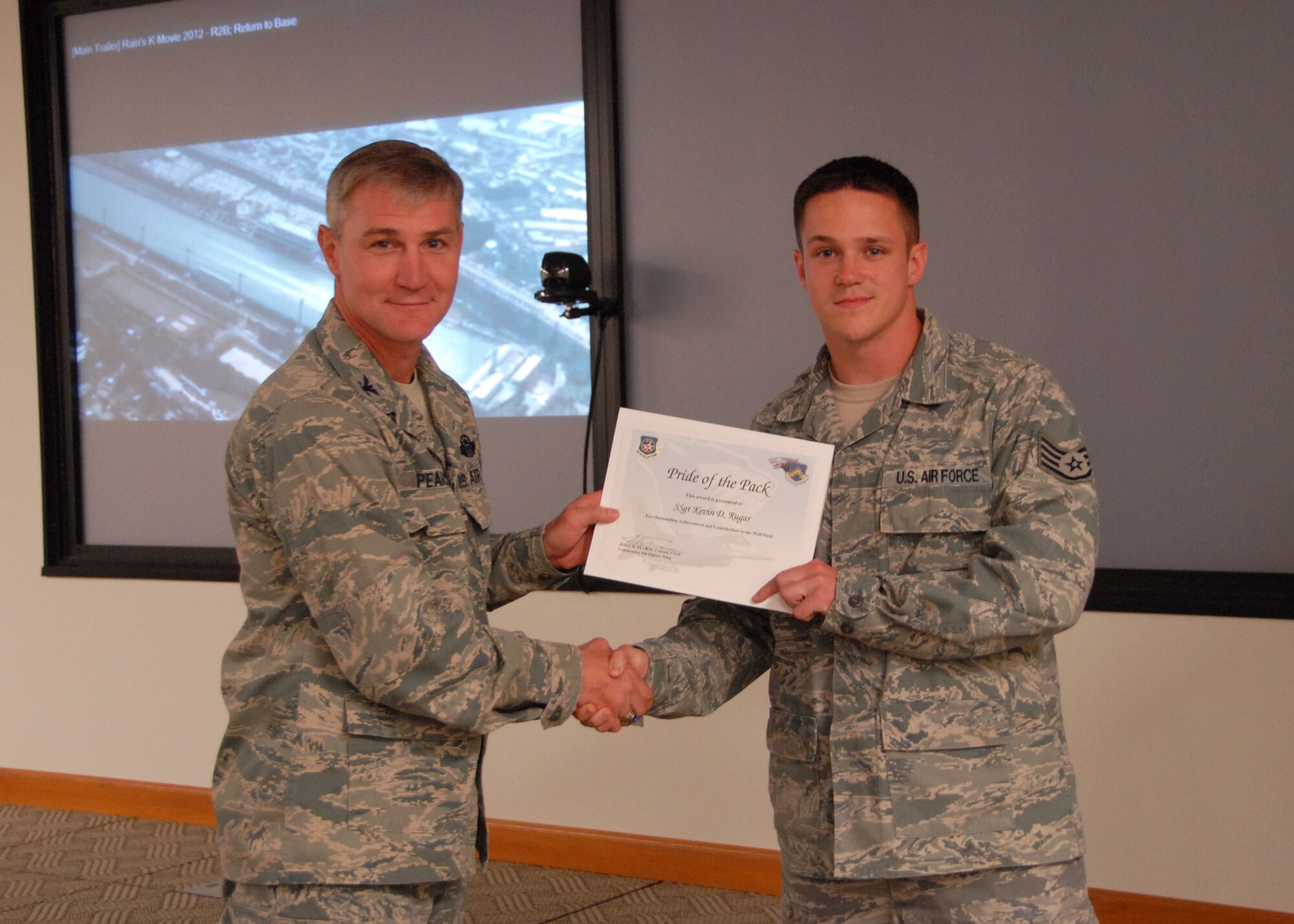 Col. John Pearse, left, 8th Fighter Wing commander, presents Staff Sgt. Kevin Rugar, 8th Communications Squadron radio frequency transmissions supervisor, with the weekly “Pride of the Pack” award Oct. 11, 2012, at Kunsan Air Base, Republic of Korea. Rugar was nominated for the award because of several accomplishments including eliminating radio dead spots along the flightline. (U.S. Air Force photo/Capt. Sheila Johnston