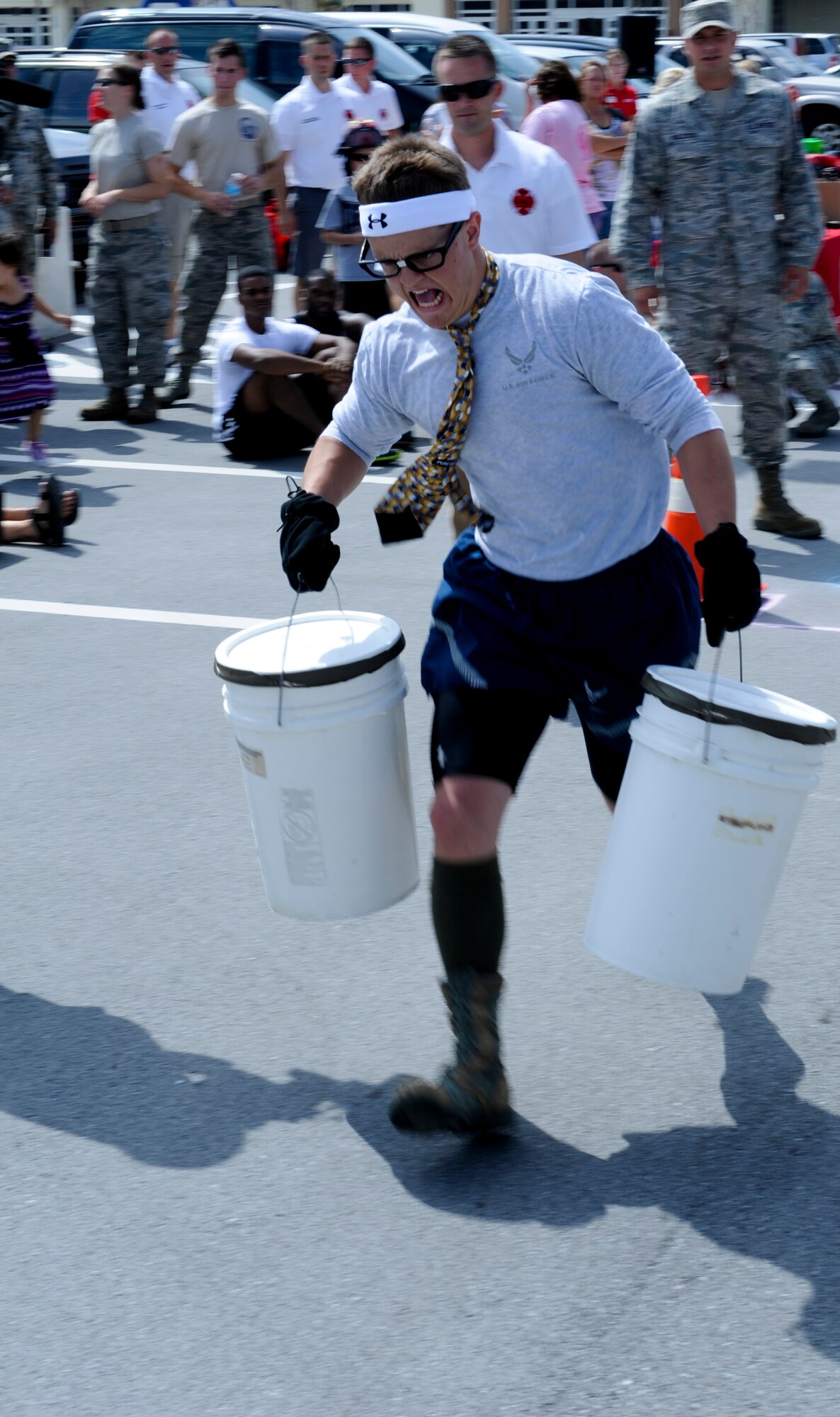 U.S. Air Force Airman 1st Class Beau Burton, 18th Contracting Squadron contracting specialist, runs with 45-pound buckets of water during a Fire Muster team building event on Kadena Air Base, Japan, Oct. 12, 2012. As team captain of the "Desk Jockeys", Burton led his team to victory winning the entire competition. (U.S. Air Force photo/Airman 1st Class Justin Veazie)