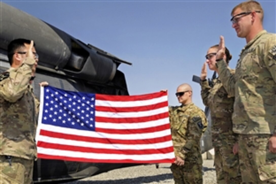 U.S. Army Spcs. Traci Sturdevant and Christopher Sturdevant re-enlist during a ceremony on the flightline on Forward Operating Base Spin Boldak, Afghanistan, Oct. 14, 2012. The Sturdevants, both medics, are married and assigned to 5th Battalion, 20th Infantry Regiment.