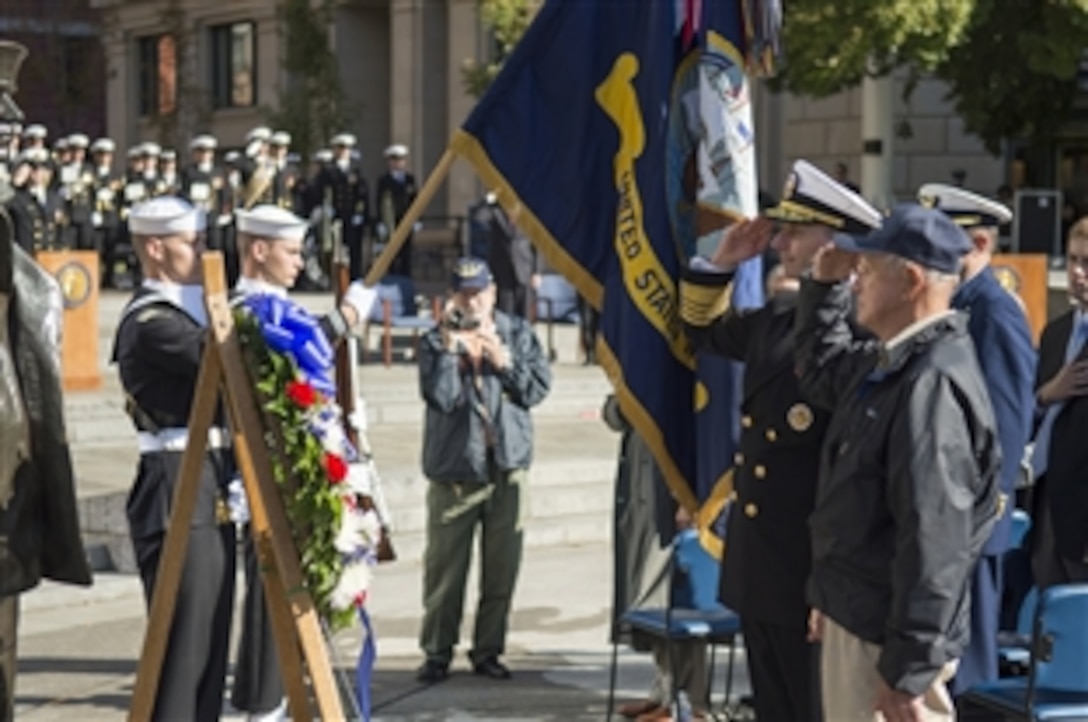 Navy Adm. Jonathan W. Greenert, chief of Naval Operations, former USS Davis crew members and members in the audience salute a wreath placed in front of the Lone Sailor statue at the U.S. Navy Memorial in honor of the crew who served aboard the Davis in Washington, D.C., Oct. 13, 2012. 