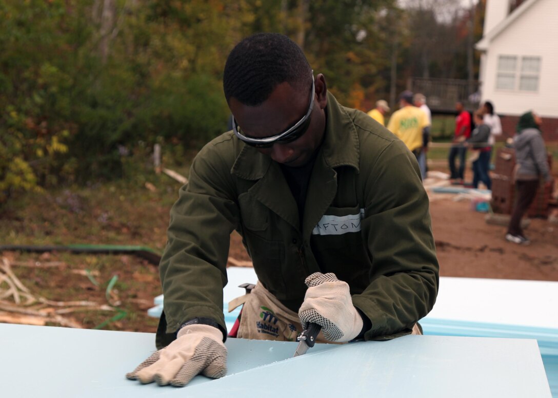 Staff Sgt. Clarence W. Crafton, a recruiter assigned to RS Nashville, cuts a piece of insulation during a volunteer build for Habitat for Humanity on Oct. 14, 2012. During the build Marines and poolees came together to assist in placing insulation, installing siding and other projects.