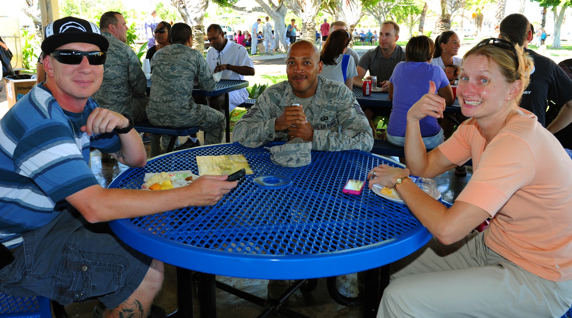 Pacific Air Forces Airmen and their families pose for a photo while relaxing and enjoying the day during the Mahalo Bash, at Joint Base Pearl Harbor-Hickam, Hawaii, Oct. 12, 2012. The Mahalo Bash is an annual event hosted by the Pacific Air Forces commander which included live performances from the U.S. Air Force Band of the Pacific-Hawaii group “Hana Hou,” and food and activities for children and adults. (U.S. Air Force photo/Tech. Sgt. Jerome S. Tayborn)