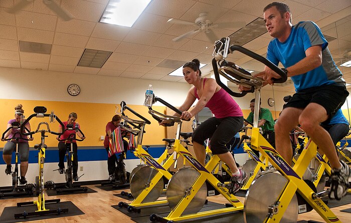 Capt. Paul Anderson, 64th Rescue Squadron F-16 Fighting Falcon pilot, and Capt. Christina Anderson, 99th Aerospace Medical Squadron physiologist, participate in a spin class at the Health and Wellness Center Oct. 15, 2012, at Nellis Air Force Base, Nev. Spin class is a low impact workout that avoids strike or impact to the joints, reducing damage. (U.S. Air Force photo by Staff Sgt. Christopher Hubenthal))