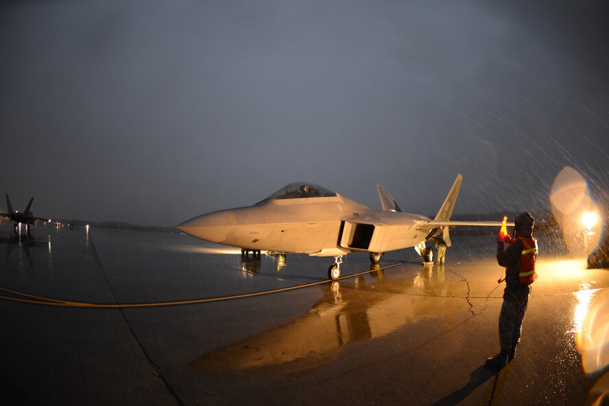 Airmen from the 3rd and 477th Aircraft Maintenance Squadrons perform safety checks on an F-22 just prior to hot pit refueling the jet.  Hot pit refueling is a procedure performed in order to rapidly refuel the aircraft and allow it to complete a second sortie in a short amount of time. During a hot pit refuel the pilot will stay in the cockpit with the jet running while the maintenance crews perform safety checks and refuel the aircraft allowing it to return to flight in less than 30 minutes.    (U.S. Air Force Reserve/Tech. Sgt. Dana Rosso) 