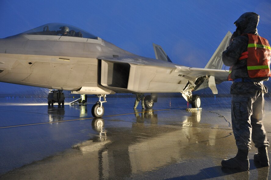 Airmen from the 3rd and 477th Aircraft Maintenance Squadrons perform safety checks on an F-22 just prior to hot pit refueling the jet.  Hot pit refueling is a procedure performed in order to rapidly refuel the aircraft and allow it to complete a second sortie in a short amount of time. During a hot pit refuel the pilot will stay in the cockpit with the jet running while the maintenance crews perform safety checks and refuel the aircraft allowing it to return to flight in less than 30 minutes.    (U.S. Air Force Reserve/Tech. Sgt. Dana Rosso) 