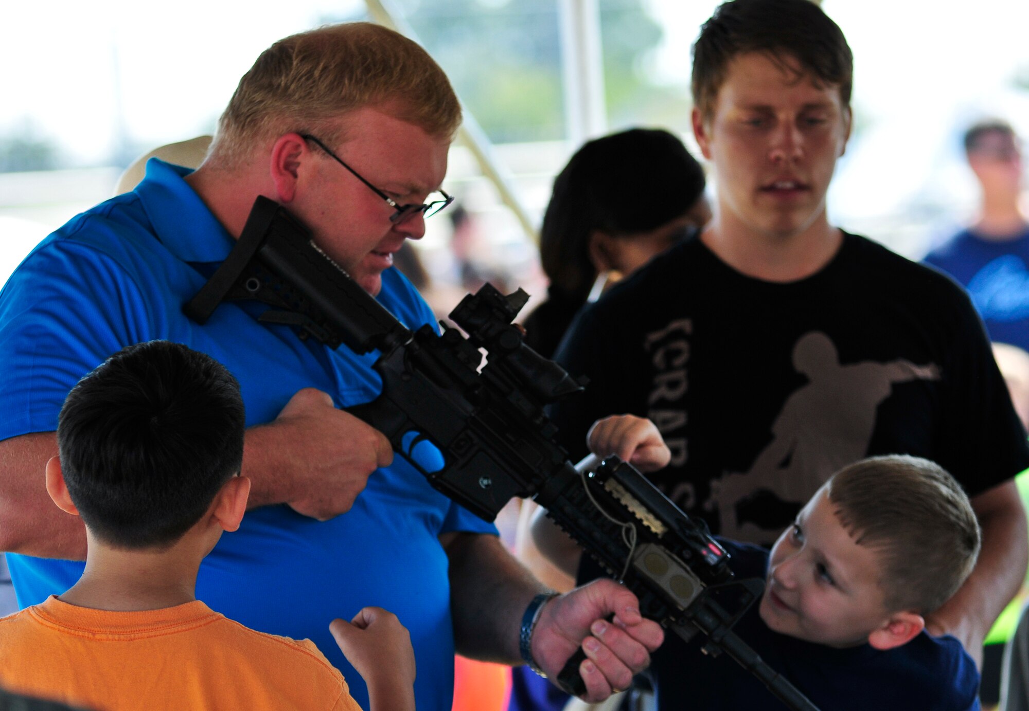 Children and parents check out Air Force weaponry at the 919th Security Forces Squadron tent at Duke Field’s Family Day event Oct. 13.  The 919th Special Operations Wing sets aside a special day each year to show appreciation for its reservists and their family members.  Events include food, music, sports, children’s games, etc.  (U.S. Air Force photo/Tech. Sgt. Cheryl Foster)