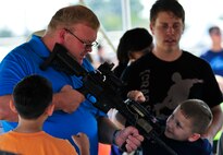Children and parents check out Air Force weaponry at the 919th Security Forces Squadron tent at Duke Field’s Family Day event Oct. 13.  The 919th Special Operations Wing sets aside a special day each year to show appreciation for its reservists and their family members.  Events include food, music, sports, children’s games, etc.  (U.S. Air Force photo/Tech. Sgt. Cheryl Foster)