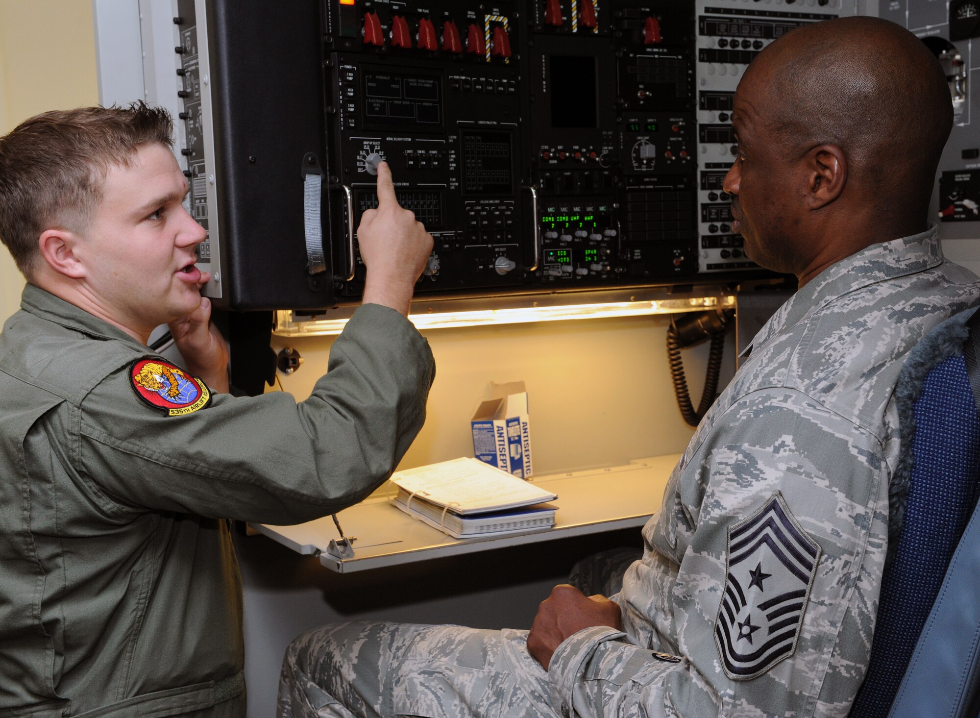 Staff Sgt. Colin Coleman, 535th Airlift Squadron loadmaster, demonstrates how to operate the C-17 loadmaster simulator to Chief Master Sgt. Jerry Moore, command chief of 11th Air Force at Joint Base Elmendorf-Richardson, Alaska, during a visit to the 535th Airlift Squadron Oct. 15 at Joint Base Pearl Harbor-Hickam, Hawaii. As a result of the recent deactivation of 13th Air Force, the 15th Wing here and 36th Wing at Andersen AFB, Guam are now
assigned to 11th Air Force. (U.S. Air Force photo by Staff Sgt. Nathan Allen)
