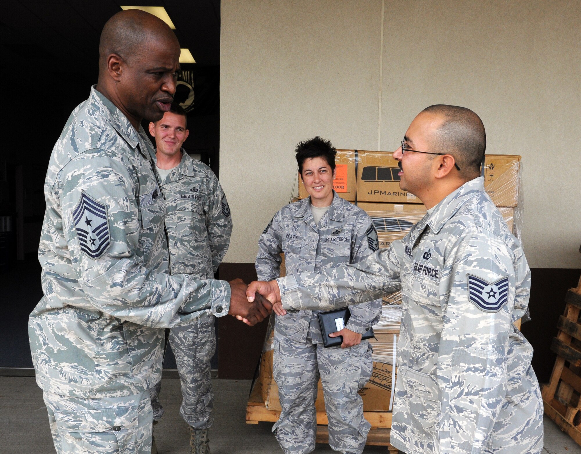 Chief Master Sgt. Jerry Moore, command chief of 11th Air Force at Joint Base Elmendorf-Richardson, Alaska, gives a coin to Tech. Sgt. Daniel Hinojosa, 15th Operations Support Squadron C-17 Globemaster III aircrew flight equipment operations NCO-in-charge, during a visit to the 535th Airlift Squadron Oct. 15 at Joint Base Pearl Harbor-Hickam, Hawaii. As a result of the recent deactivation of 13th Air Force, the 15th Wing here and 36th Wing at Andersen AFB, Guam are now assigned to 11th Air Force. (U.S. Air Force photo by Staff Sgt. Nathan Allen)
