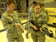 Air Force Reserve Maj. Jedd Miloud holds up an Airman's Manual while assisting Master Sgt. Sherri Libby's M-16 weapons training as they both prepare for the 302nd Airlift Wing's upcoming Operational Readiness Inspection Oct. 16 at Peterson Air Force Base, Colo. The M-16 overview covered operating the weapon, troubleshooting weapon jams, and how to properly clear the rifle when storing. Hundreds of other 302nd AW members joined Miloud and Libby as they each completed final refresher training in preparation for the ORI the following week. Miloud is a 302nd AW judge advocate general and Libby is one of the wing's paralegals. (U.S. Air Force photo/Staff Sgt. Stephen J. Collier)
