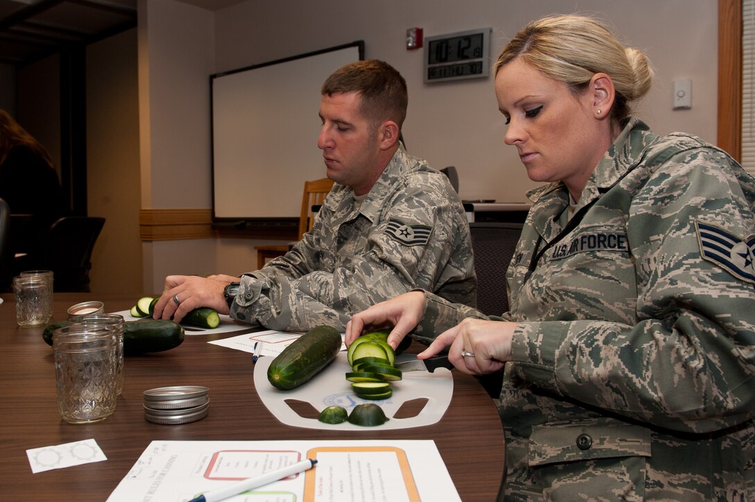 Staff Sgt. Christine Green, 28th Logistics Readiness Squadron inventory NCO in charge (right), and her husband, Staff Sgt. Jacob Green, 28th LRS vehicle maintenance quality assurance technician, cut cucumbers during a canning workshop at the Airman and Family Readiness Center on Ellsworth Air Force Base, S.D., Oct. 11, 2012. The goal of the workshop was to educate Airmen and families on ways to save some money and preserve food by canning. (U.S. Air Force photo by Airmen 1st Class Kate Thornton-Maurer/Released)