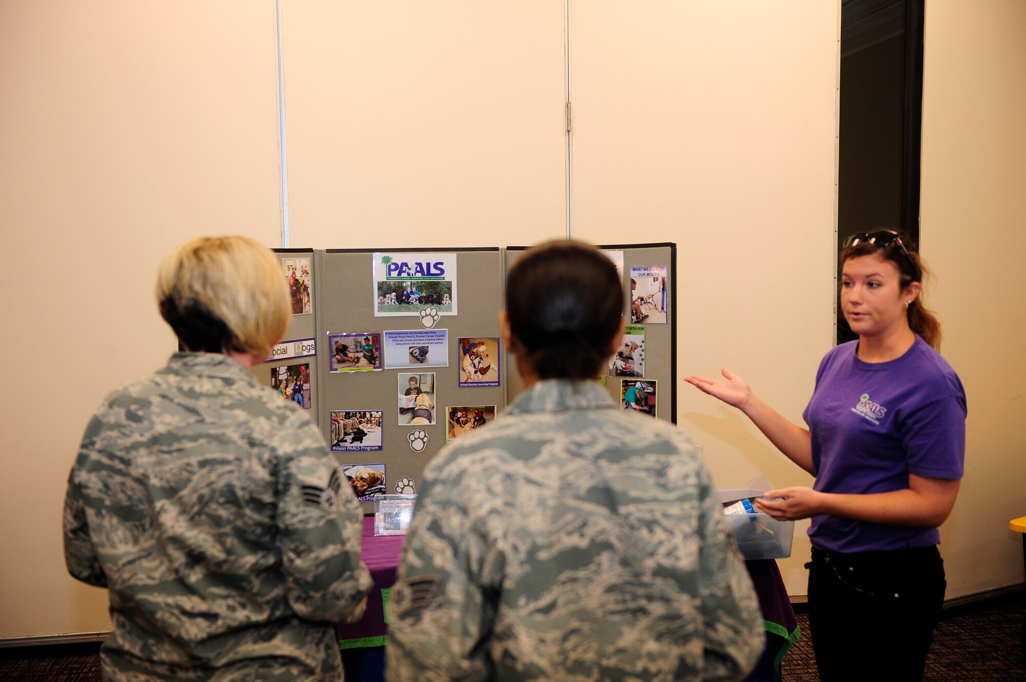 Airmen attending the Combined Federal Campaign fair listen to the PAALS (Palmetto Animal Assisted Life Services) representative explain how their program works, Shaw Air Force Base, S.C., Oct. 10, 2012. The Combined Federal Campaign will be in effect and accepting donations until Nov. 16. (U.S. Air Force photo by Airman 1st Class Daniel Blackwell/Released)