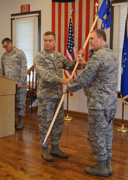 Brig. Gen. David Newman, chief of the joint staff of the Missouri National Guard, hands the 157th Air Operations Group guidon to Col Richard Chapman as Chapman assumes command of both the 157th AOG and the Jefferson Barracks Air National Guard Station in South St. Louis County, Oct 13.  (National Guard Photo by Bill Phelan)  