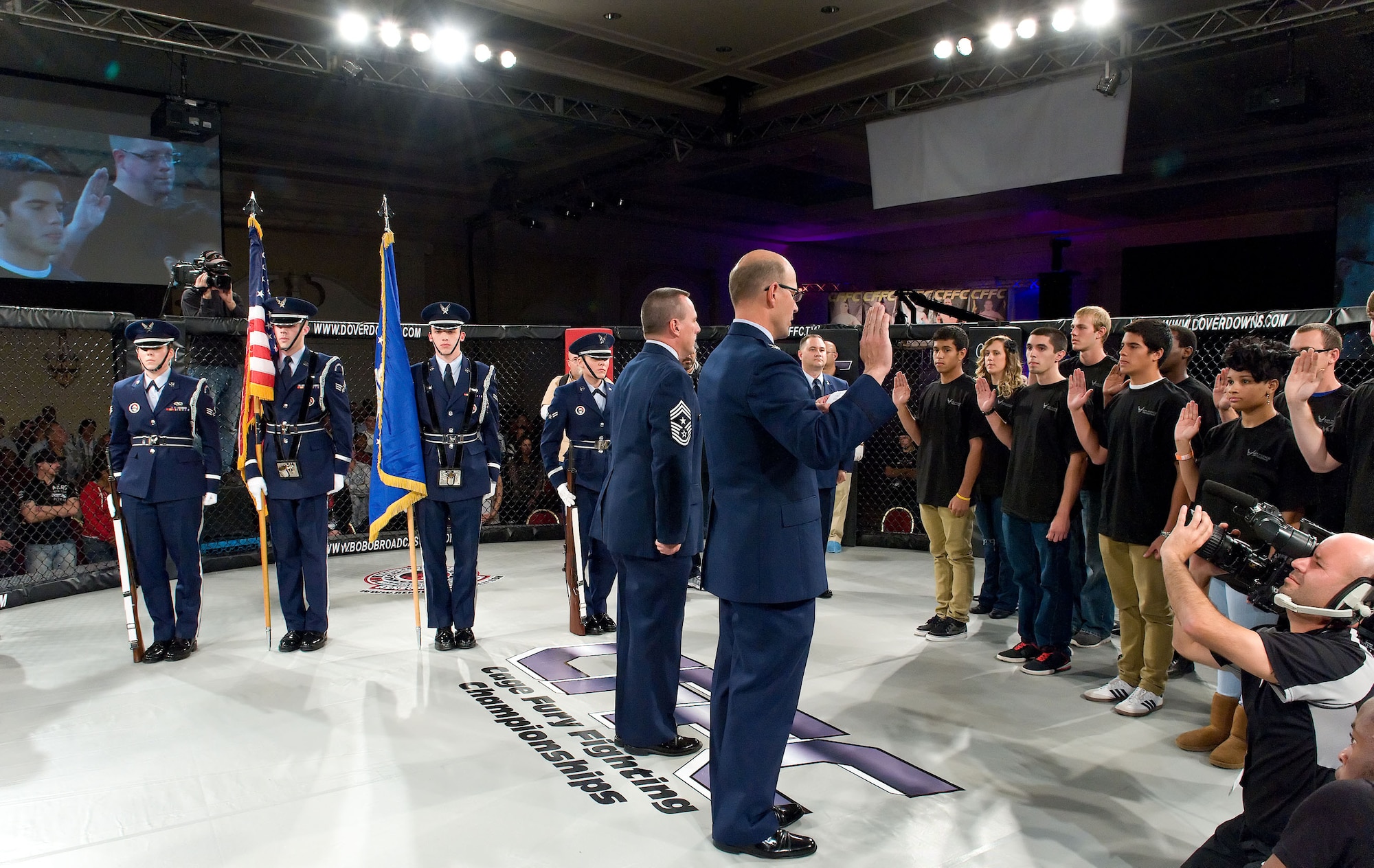 Col. Raymond A. Kozak, center, commander of the 512th Airlift Wing, swears in members of the Delayed Entry Program into the Air Force Reserves Oct. 13, 2012, at Dover Downs in Dover, Del. The 512th AW held a mass enlistment ceremony during Delaware's first professional mixed martial arts event at the hotel and casino. (U.S. Air Force photo by Roland Balik)