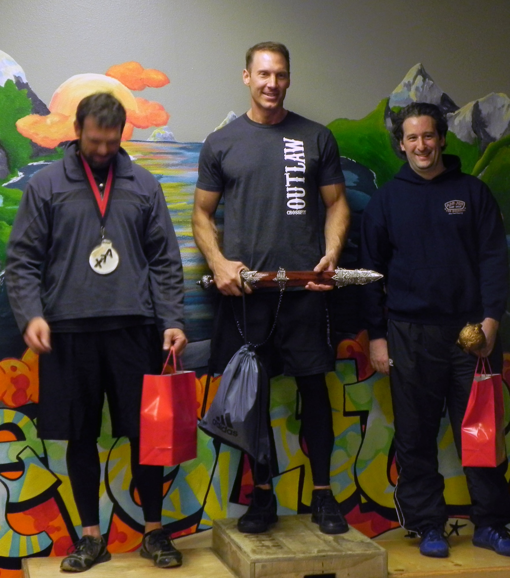 Lt. Col. David Piffarerio, 302nd FS commander (center) won first place in the over 40 male division of the 2012 CrossFit Alaska State Championships in Anchorage Oct. 13.  “I’ve been doing cross fit since 2007 and I have never looked back,” said Piffarerio. “It's a phenomenal fitness program as I'm in the best shape of my life.  It's very challenging but rewarding at the same time as you meet fitness goals and accomplish things you never thought you could.” (Courtesy Photo)