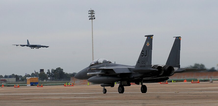 A B-52H Stratofortress prepares to land as an F-15E Strike Eagle taxis out to launch on Barksdale Air Force Base, La., Oct. 16. Over 160 Airmen from Seymour Johnson AFB, N.C., are here on temporary duty with the F-15s for Green Flag East, a training exercise that helps Airmen from different career fields work together with Army personnel to prepare for deployments in combat environments. (U.S. Air Force photo/Senior Airman Kristin High)(RELEASED)
