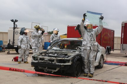 A firefighter from the 902nd Civil Engineer Squadron holds a windshield cut from a car during an extrication technique demonstration for Airmen and family members at the annual Fire Prevention Week celebration Oct. 13 at Joint Base San Antonio-Randolph. Fire Prevention Week was established to commemorate the Great Chicago Fire of 1871. (U.S. Air Force photo by Josh Rodriguez)