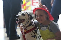 Lily Rodriguez, a dependent of a Joint Base San Antonio-Randolph service member, hugs a Dalmatian at a Fire Prevention Week celebration Oct. 13 at Randolph. Fire Prevention Week was established to commemorate the Great Chicago Fire, the 1871 conflagration that killed more than 250 people, left 100,00 homeless, destroyed more that 17,400 structures and burned more than 2,000 acres. The fire began Oct. 8, but continued into and did most of its damage Oct. 9, 1871. (U.S. Air Force photo by Josh Rodriguez)