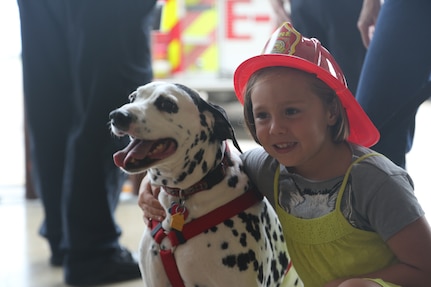 Lily Rodriguez, a dependent of a Joint Base San Antonio-Randolph service member, hugs a Dalmatian at a Fire Prevention Week celebration Oct. 13 at Randolph. Fire Prevention Week was established to commemorate the Great Chicago Fire, the 1871 conflagration that killed more than 250 people, left 100,00 homeless, destroyed more that 17,400 structures and burned more than 2,000 acres. The fire began Oct. 8, but continued into and did most of its damage Oct. 9, 1871. (U.S. Air Force photo by Josh Rodriguez)