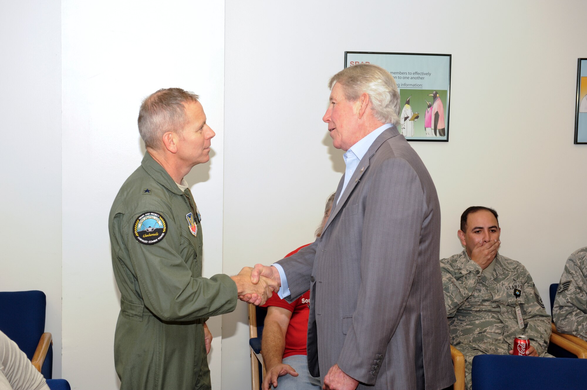 Brigadier Gen. John K. McMullen, 325th Fighter Wing commander, presents James Blanchard, 325th Medical Support Squadron health benefits advisor, with a coin recently in recognition of his many years of service to the Air Force. Blanchard served 30 years on active duty as an independent duty medical technician and retired as a chief master sergeant. Upon his retirement from active duty, he served nearly 20 years in civil service at Tyndall and retired Oct. 12. (U.S. Air Force photo by Chris Cokeing)   