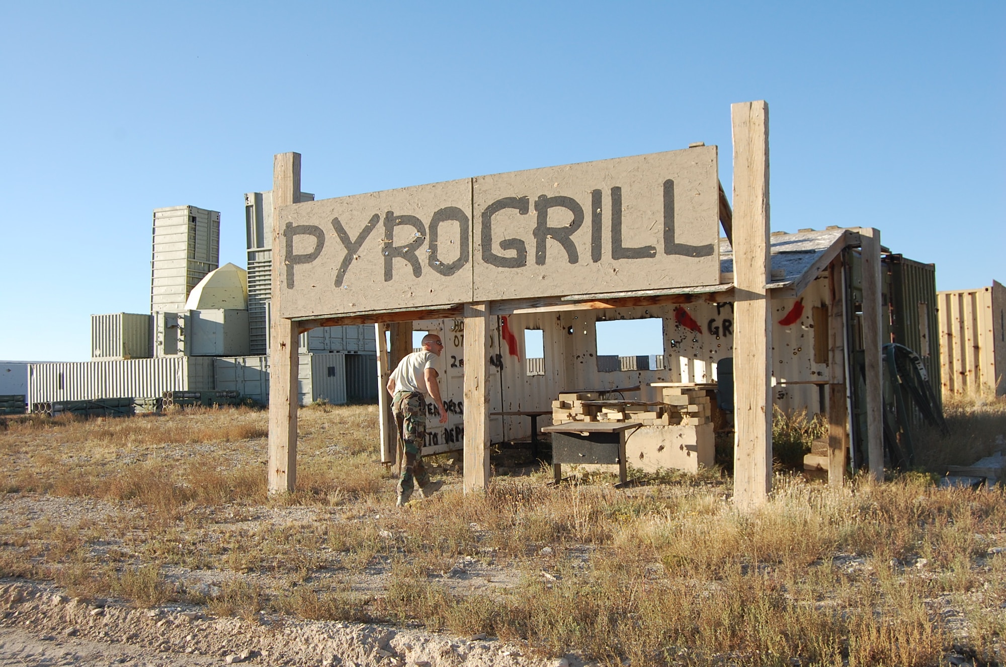 Lieutenant Col. John "Pyro" Stevenson assesses damage done to the training village, Abu Pyro. The range team constructs these villages out of freight car boxes and donated scrap materials. (U.S. Air Force Photo / Capt. Kinder Blacke)