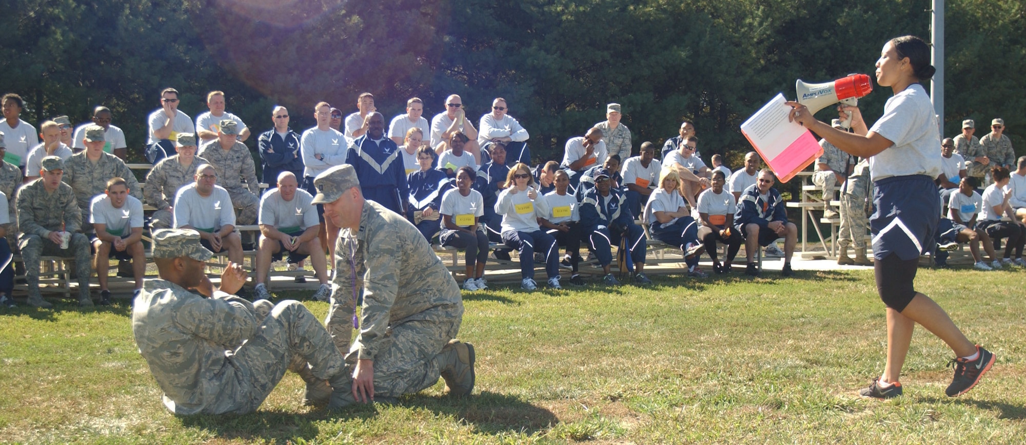 1st Lt. Michelle Anderson, the 512th Maintenance Group executive officer and event organizer, explains to participants at the Ultimate Fitness Challenge how to perform a sit-up Oct. 13, 2012, at the track, Dover Air Force Base, Del. Capt. Jeremy Reynolds, 512th Mission Support Group, and 2nd Lt. Michael Spencer, 512th MXG, demonstrated the proper technique. (U.S. Air Force photo by Senior Airman Joe Yanik)