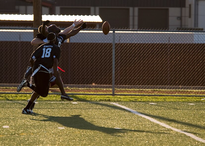 Members of the 7th Logistics Readiness Squadron football team stop a 7th Bomb Wing wide receiver from catching the ball Oct. 11, 2012, during a flag football game at Dyess Air Force Base, Texas. The Dyess intramural flag football league kicked off Oct. 9 and continues until November. Following the regular season, the top teams from each division will participate in a double elimination tournament to determine the 2012 Dyess flag football champions. (U.S. Air Force photo by Airman 1st Class Damon Kasberg/ Released)