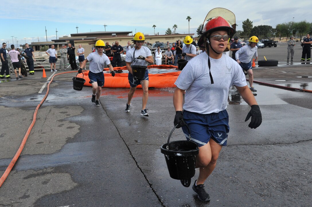 Airman 1st Class Pisay Suzuki, 56th Civil Engineer Squadron pavements and heavy equipment operator, carries a bucket of water from the drop tank during the 2012 Firefighter’s Muster Oct. 12 at Luke Air Force Base, Ariz. Suzuki was one of a four person team participating in this event held by the Luke Fire Emergency Services. (U.S. Air Force photo by Senior Airman Sandra Welch)