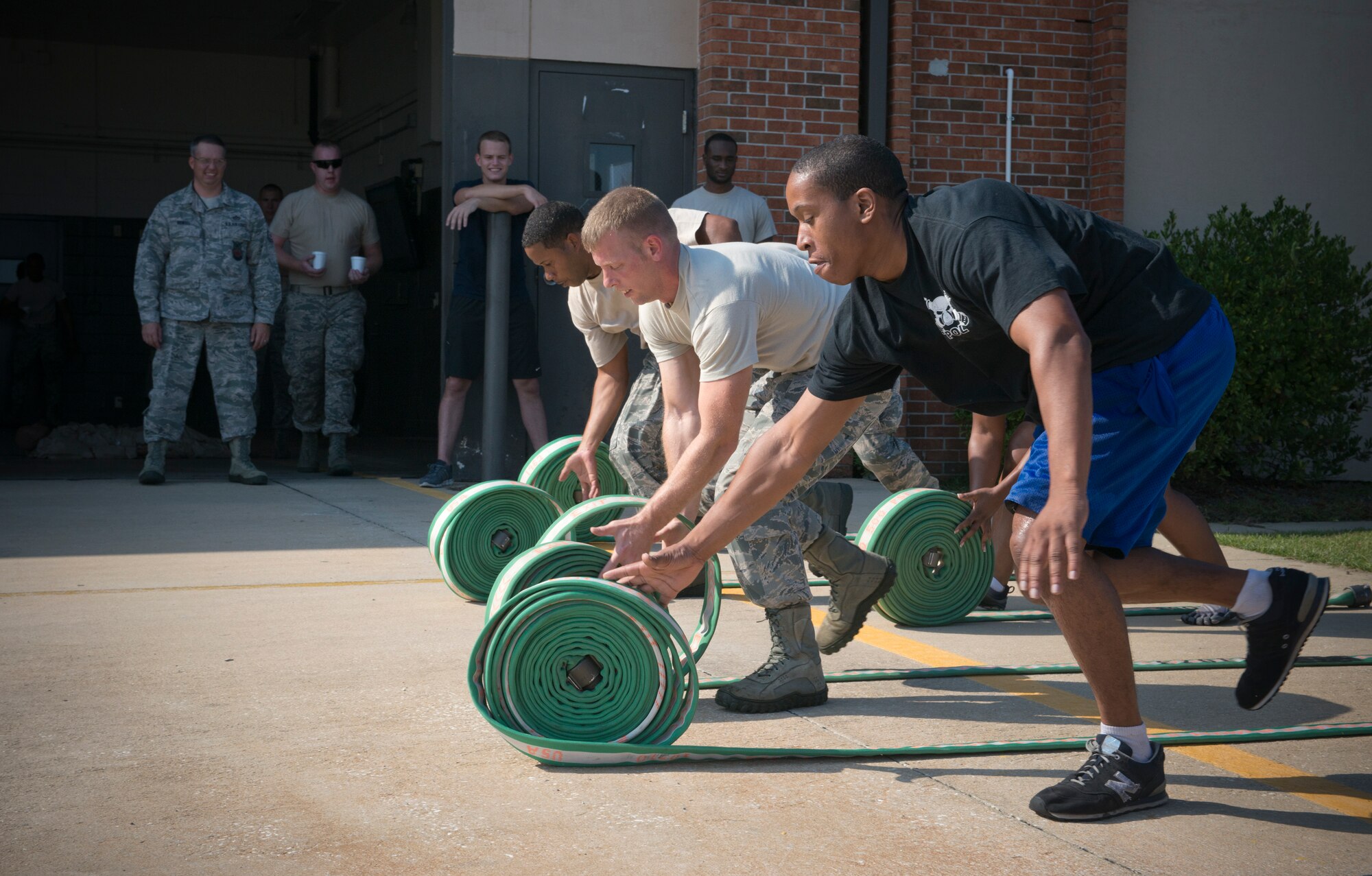 Moody Airmen participate in a hose roll during a Fire Muster Challenge at Moody Air Force Base, Ga., Oct. 12, 2012. During the challenge, members had to completely unroll five hoses, re-roll them and stack them as quickly as possible. (U.S. Air Force photo by Senior Airman Douglas Ellis/Released)
