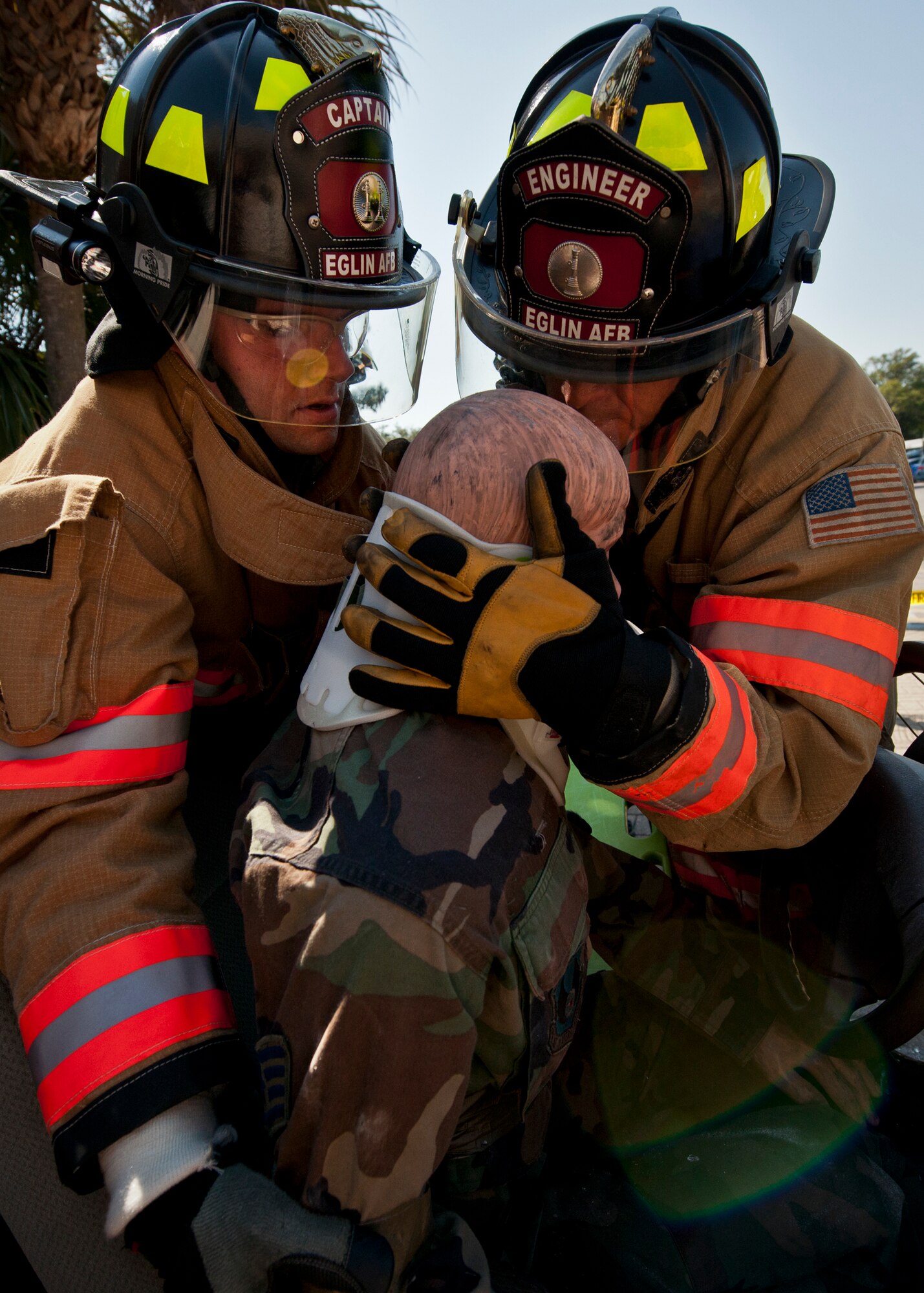 Staff Sgt. Todd Lawrence and Michael Barrow, Eglin Air Force Base firefighters, slowly remove a simulated victim from his vehicle during their car extrication demonstration at the Base Exchange Oct. 12. The firefighters demonstrated how quickly they can open up a car to free a trapped victim of an accident. (U.S. Air Force photo/Samuel King Jr.)